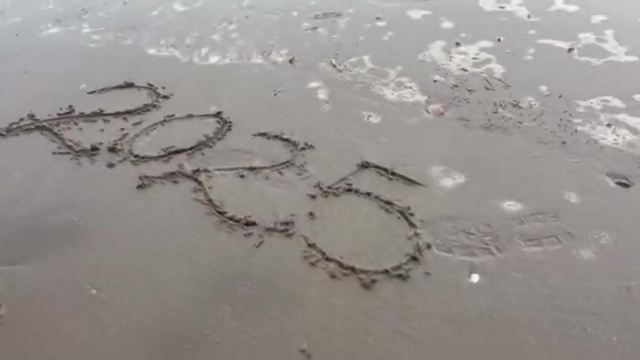 2025 written in the sand on a beach.