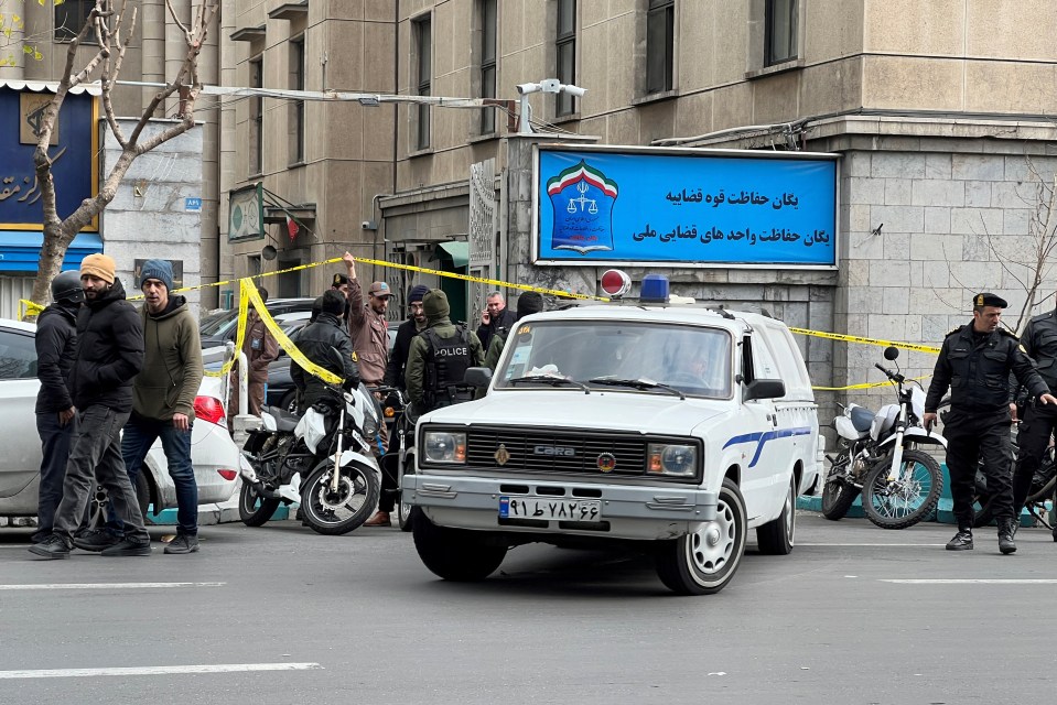 Police officers outside a judiciary building in Tehran, Iran, following the assassination of Supreme Court judges.