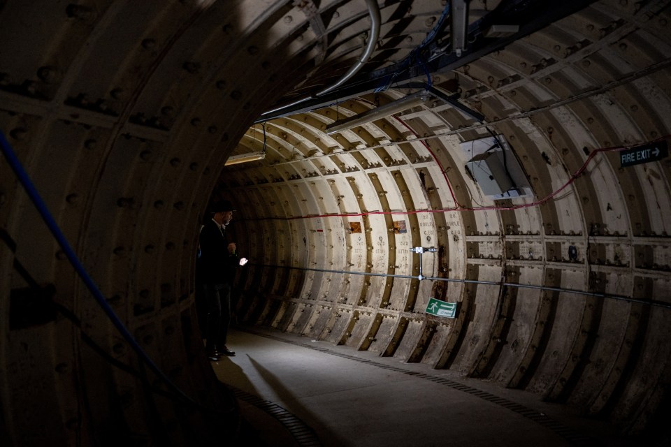 A person stands in a World War II-era tunnel.