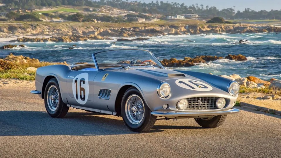 Silver 1959 Ferrari 250 GT California Spider, number 16, by the ocean.