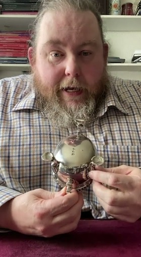 Man holding a silver container.