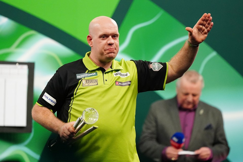 Michael van Gerwen holding a trophy after losing a darts championship.