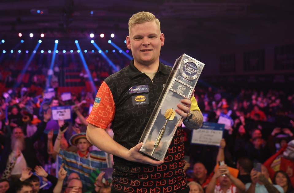 Mike De Decker of Belgium celebrates winning the BoyleSports World Grand Prix darts championship trophy.