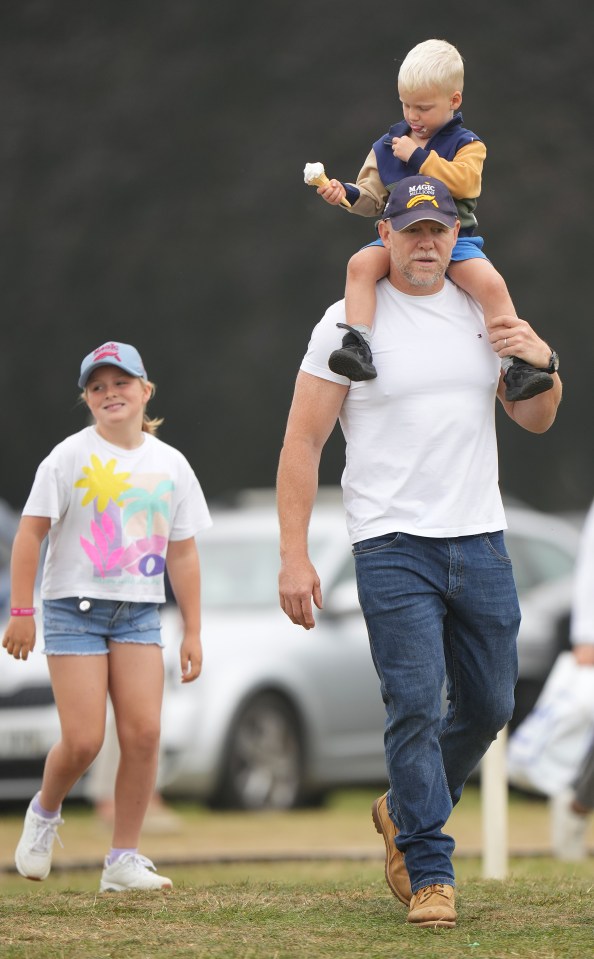 Mike Tindall carrying his son on his shoulders, with his daughter walking nearby.