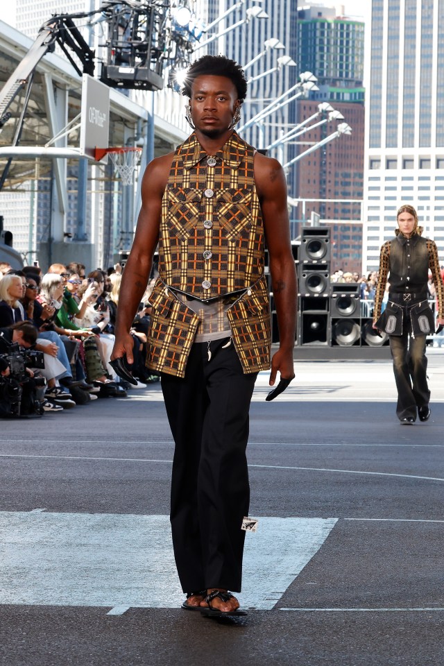 Model walking a runway during a fashion show.