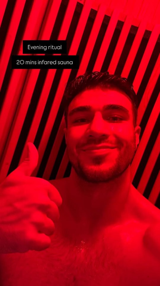 Man gives thumbs up in infrared sauna.