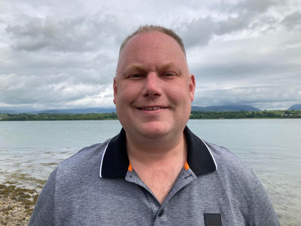 Headshot of Luke Denley by the water.