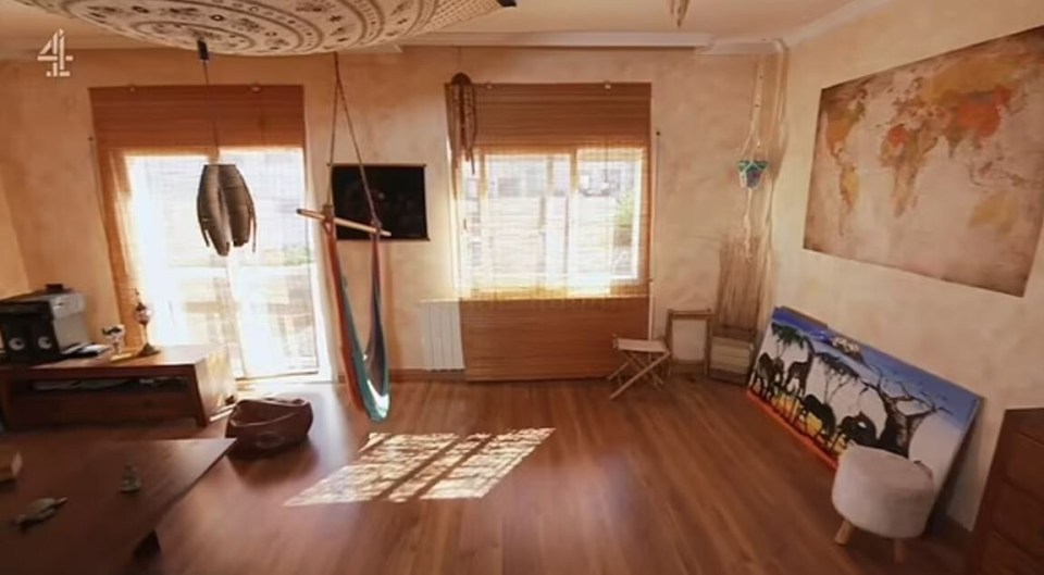 Living room with wooden floors, a hammock, and world map artwork.