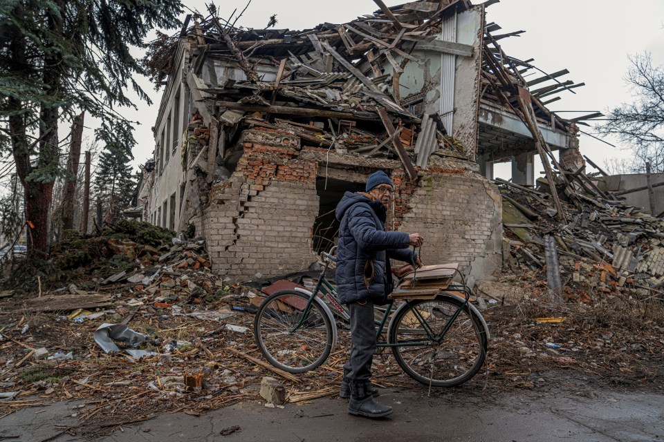 Damaged building in Kyiv, Ukraine, with rescue workers on a ladder.