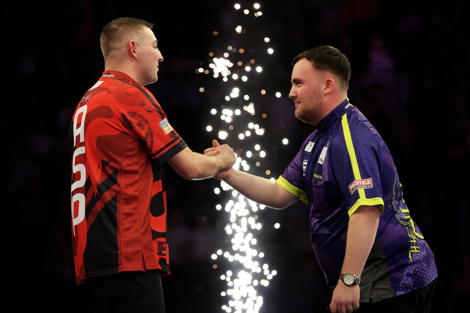 Nathan Aspinall consoles Luke Littler after a darts match.