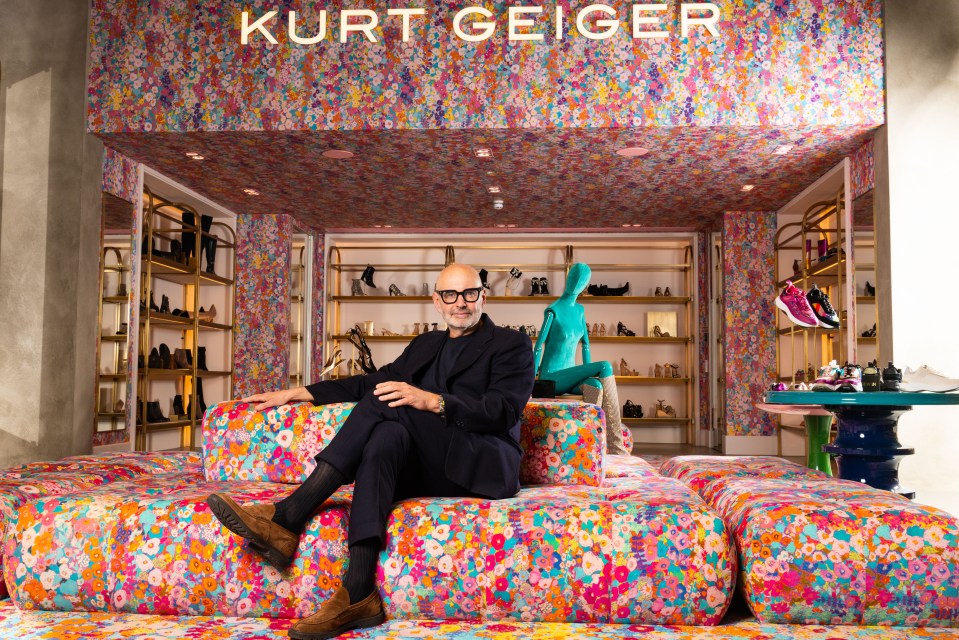 Neil Clifford, CEO of Kurt Geiger, sitting on a floral sofa in the Kurt Geiger flagship store.