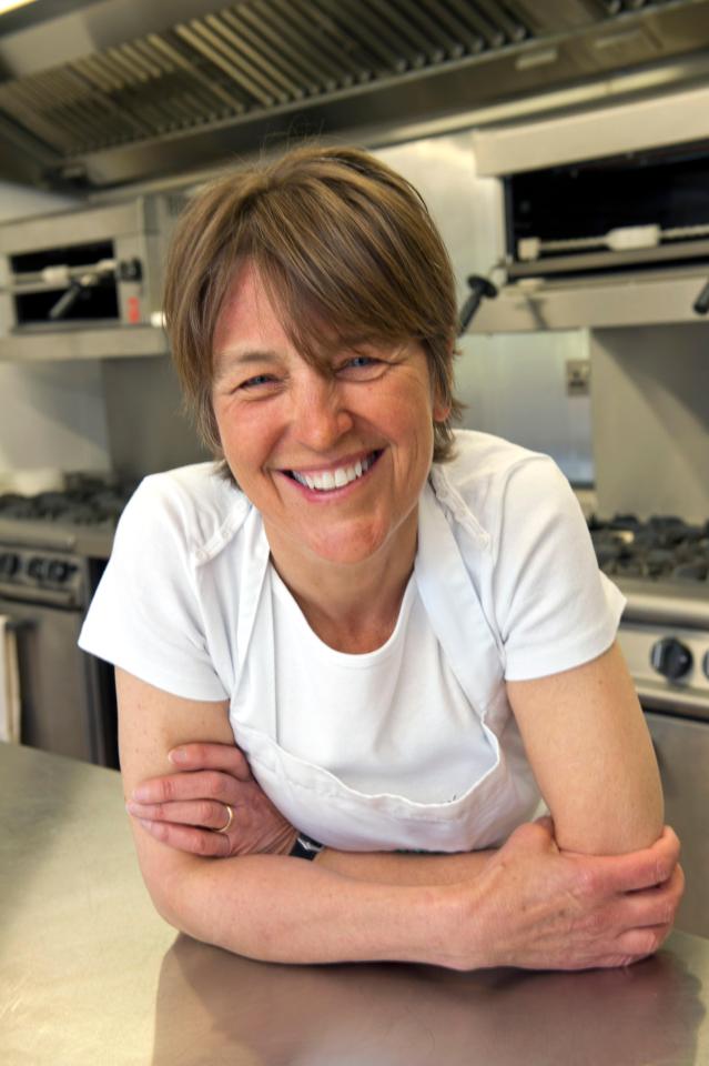 Smiling woman chef in her kitchen.