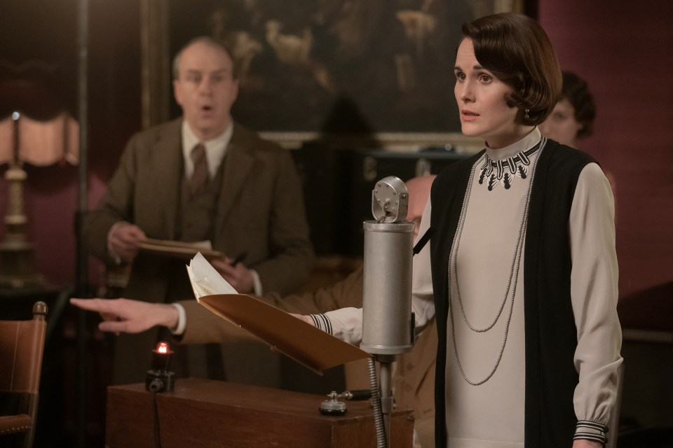 Michelle Dockery as Lady Mary in Downton Abbey: A New Era, speaking into a microphone.