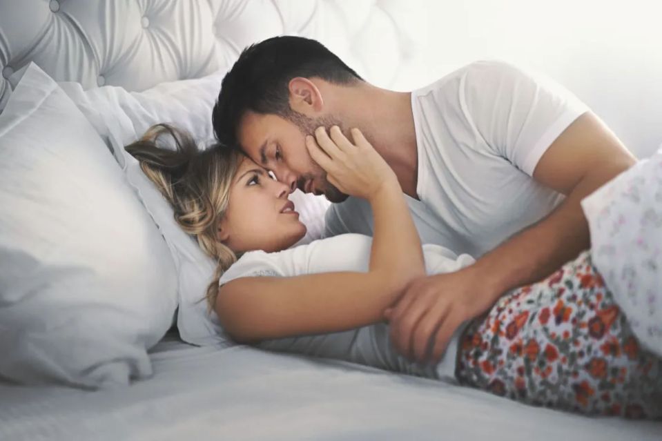 Couple embracing in bed.