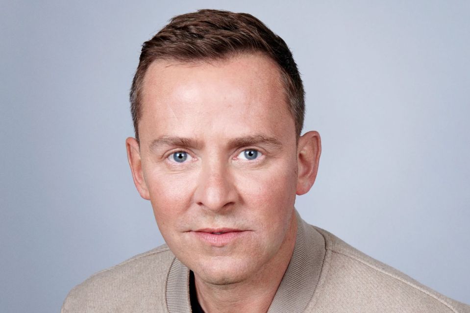 Headshot of a man with short brown hair and blue eyes.