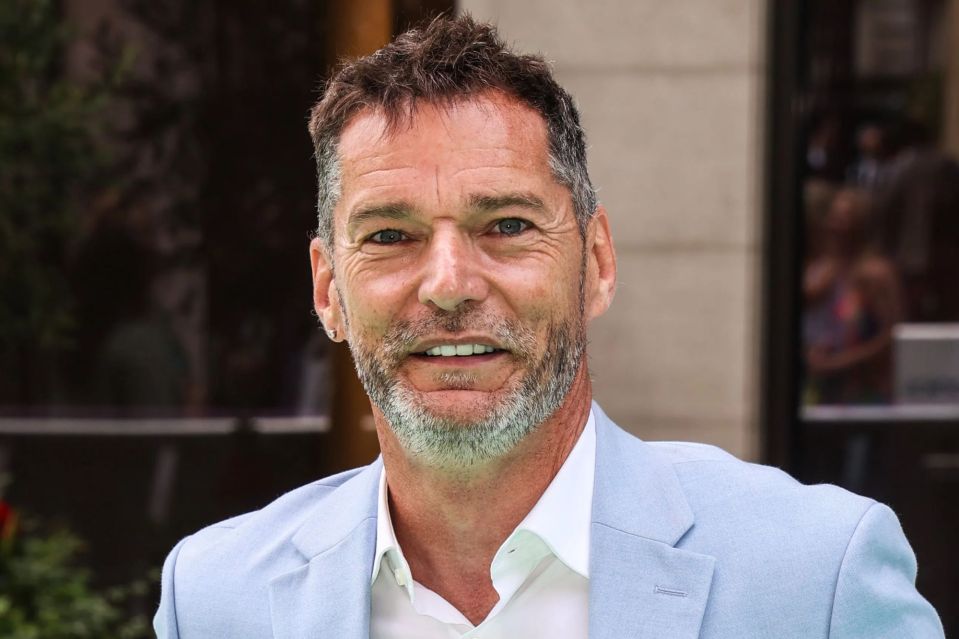 Headshot of a man in a light blue blazer.