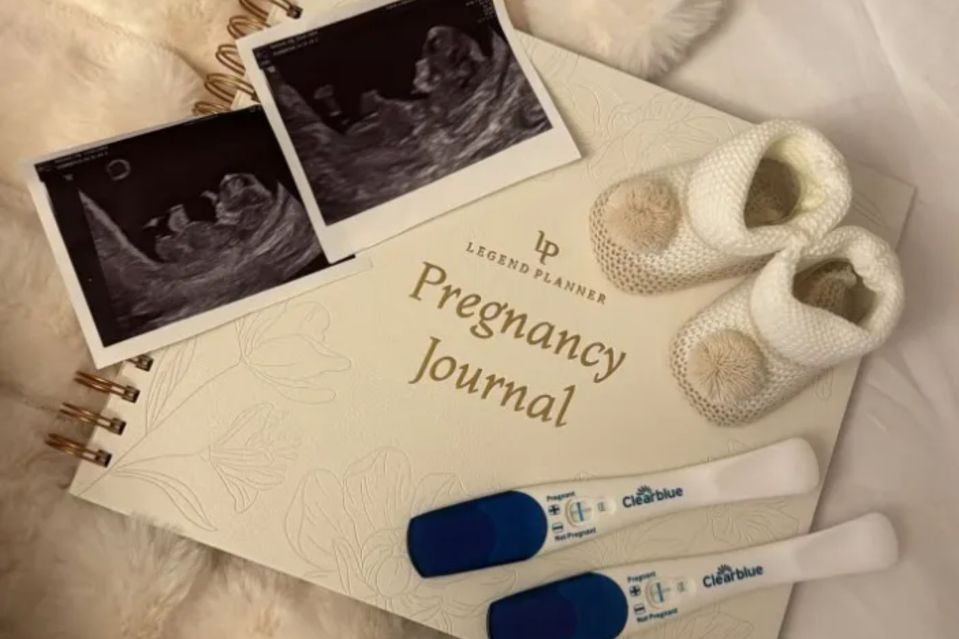 Pregnancy announcement with sonogram photos, pregnancy journal, baby booties, and positive pregnancy tests.