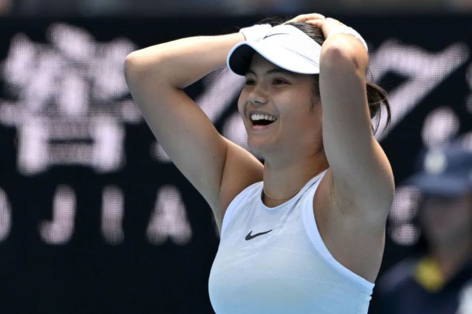 Emma Raducanu smiling on a tennis court.