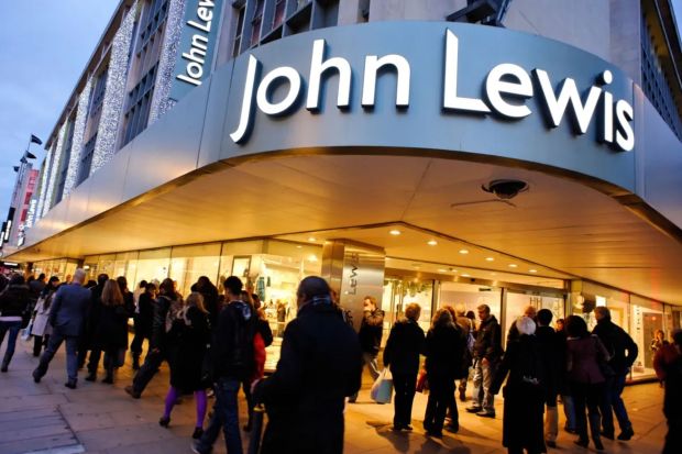 John Lewis department store entrance at night with shoppers.