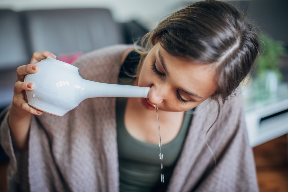 Woman using a neti pot.