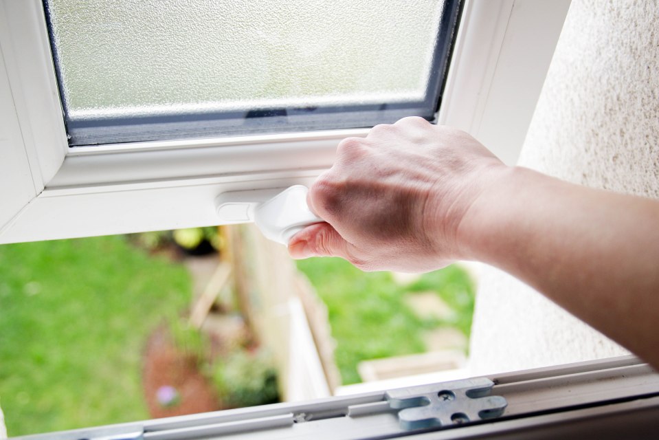 Hand opening a bathroom window.