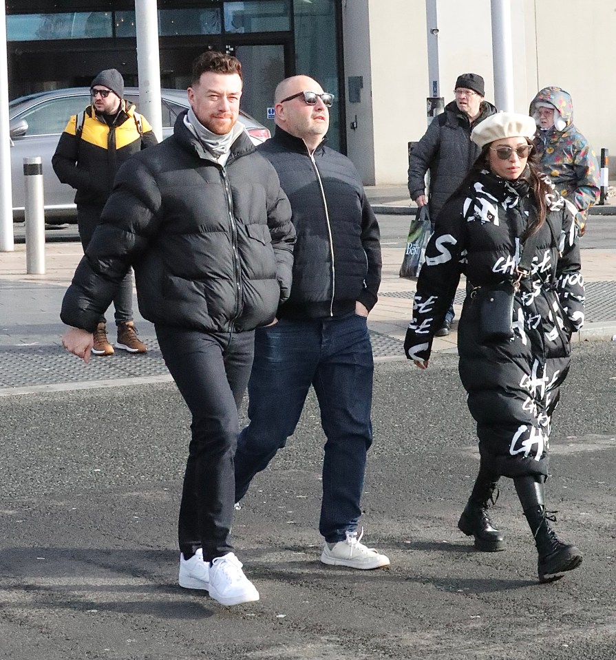 Wynne Evans and others walking across a street.