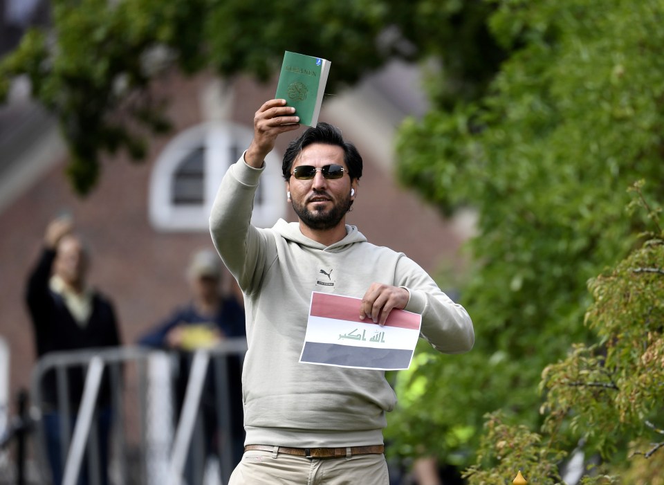 A man holds up a Quran and an Iraqi flag outside the Iraqi embassy in Stockholm.