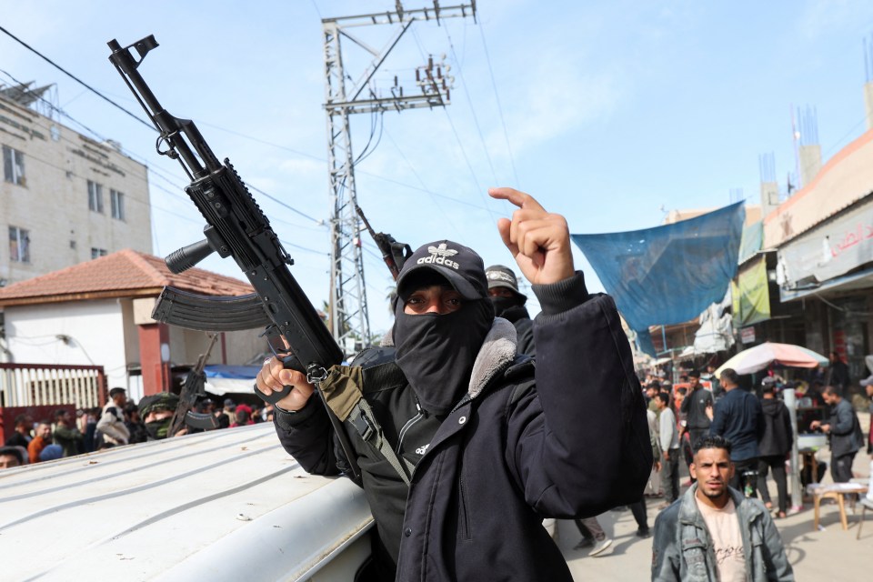 Palestinian Hamas militant with rifle in celebratory parade.