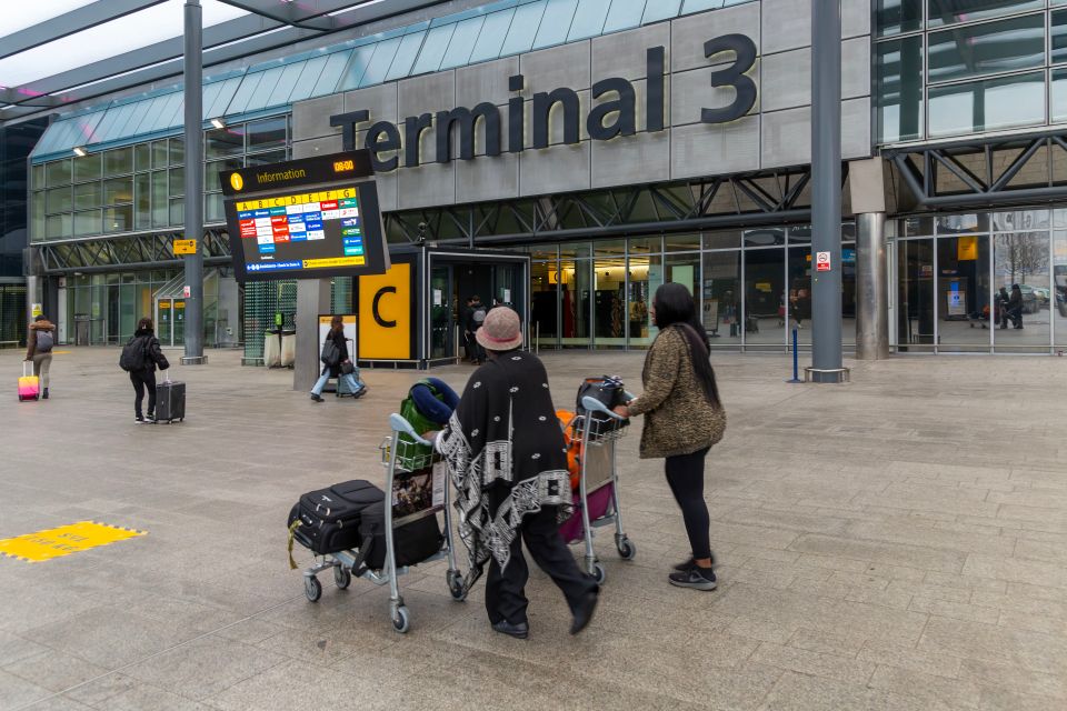 Passengers with luggage outside Terminal 3 at London Heathrow Airport.