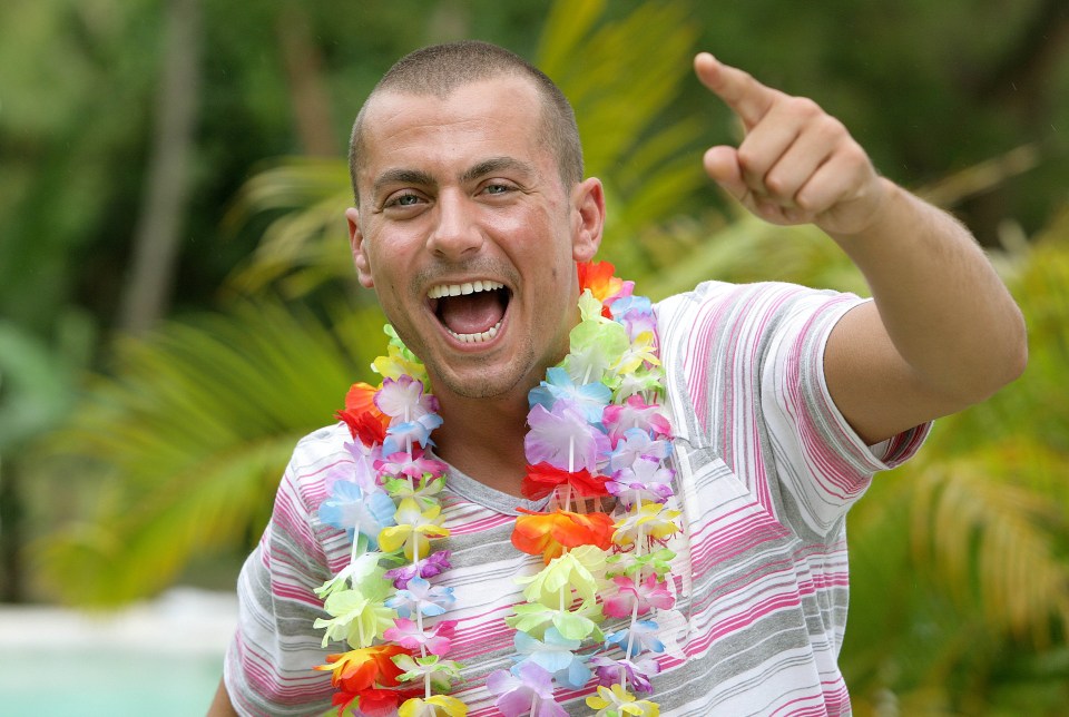 Paul Danan, Love Island star, wearing a lei and pointing.