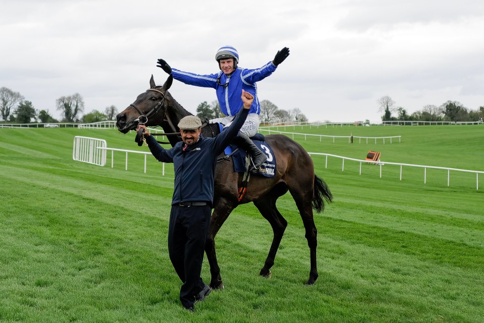 Jockey Paul Townend and a horse handler celebrating a horse race victory.