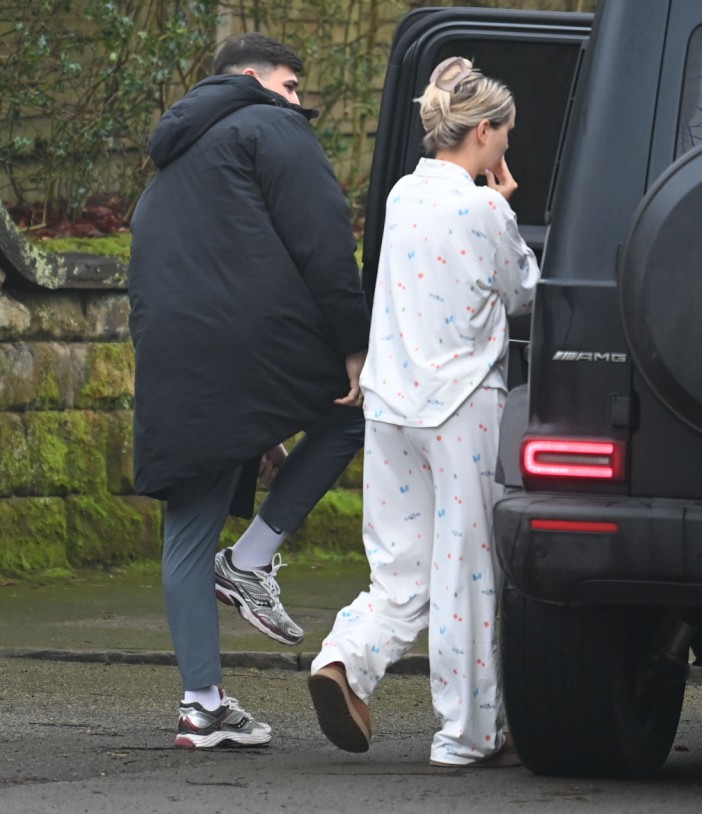 A man and woman in pajamas getting into a car.