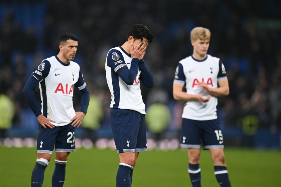 Three dejected Tottenham Hotspur players on the field after a game.