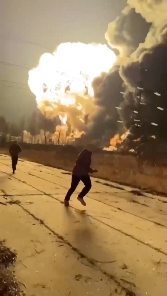 People running away from a large explosion.