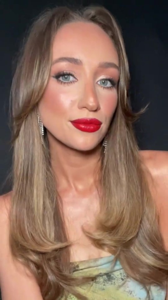 Woman with long blonde hair and red lipstick.