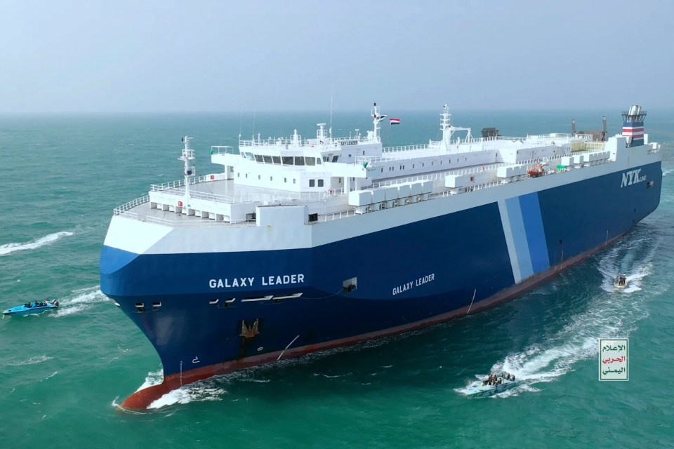 The Galaxy Leader cargo ship escorted by small boats in the Red Sea.