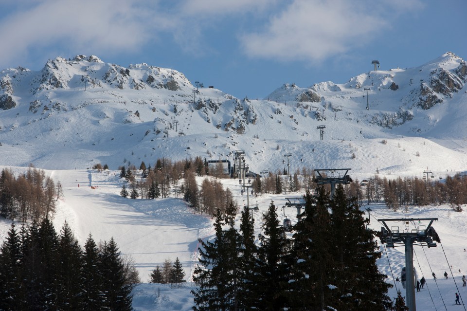 Ski lift and skiers at a snowy mountain resort.