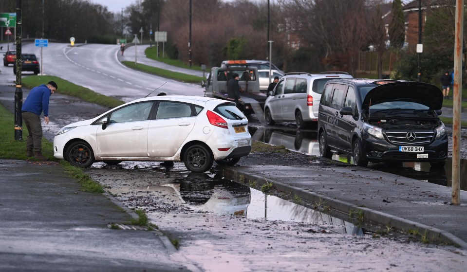 Car owners assess flood damage to their vehicles.