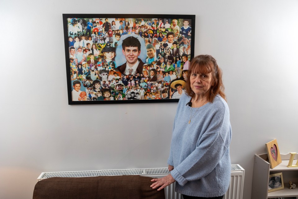 A woman stands in front of a large photo collage of her deceased son.