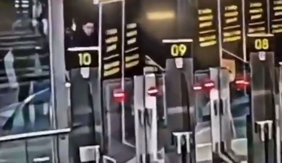 Woman crawling under airport security barrier.