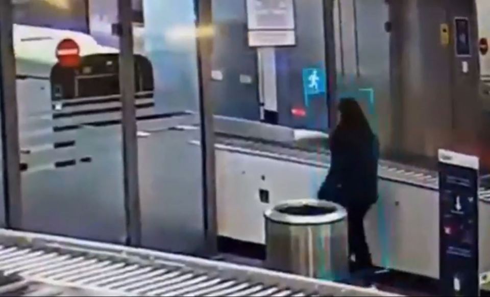 Woman crawling under airport security barrier.