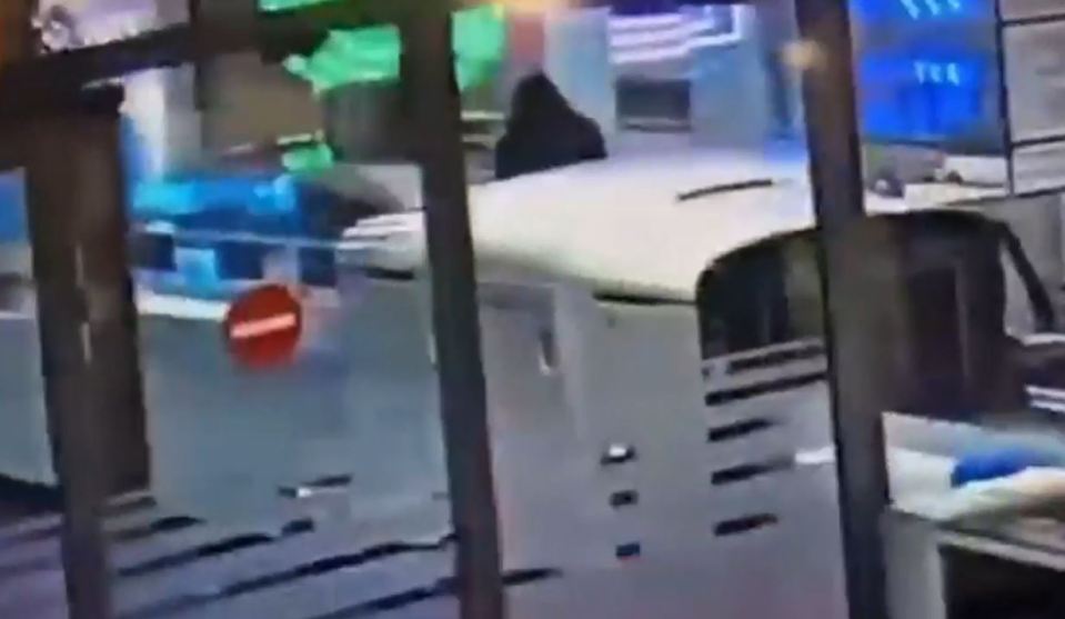 Woman crawling under airport security barrier.