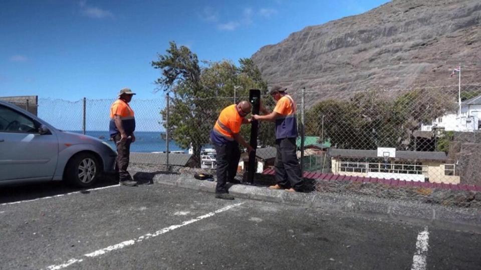 Workers installing an EV charger on a small island.