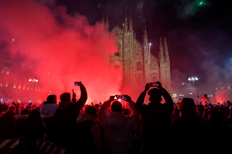 Crowd watching fireworks display in front of Milan Cathedral.