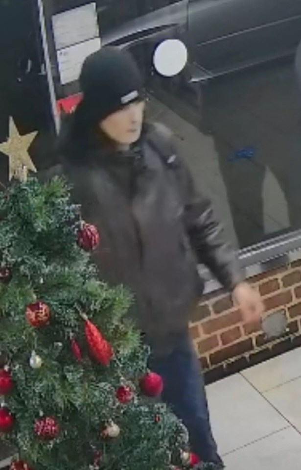 Surveillance image of a man wearing a black beanie and jacket.