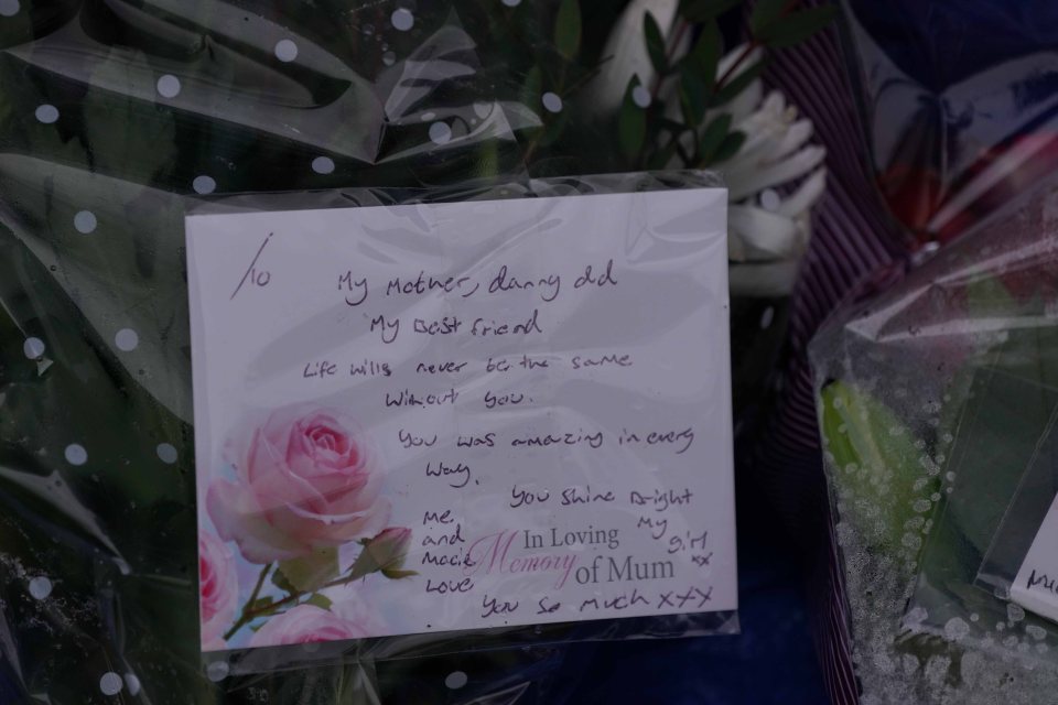 Handwritten tribute note on flowers at a crime scene.