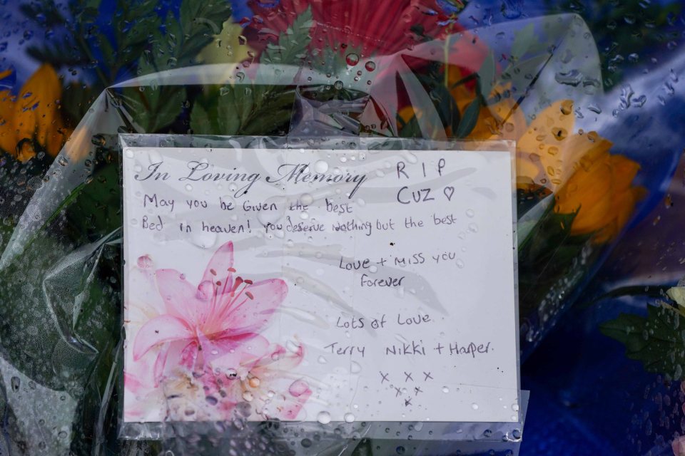 Floral tribute with a handwritten message: "In Loving Memory Cuz RIP".