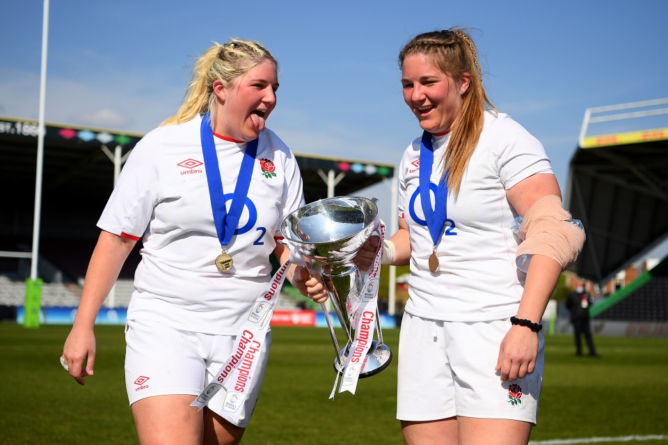 Two England rugby players holding the Six Nations trophy.