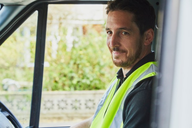 Smiling delivery driver in his van.