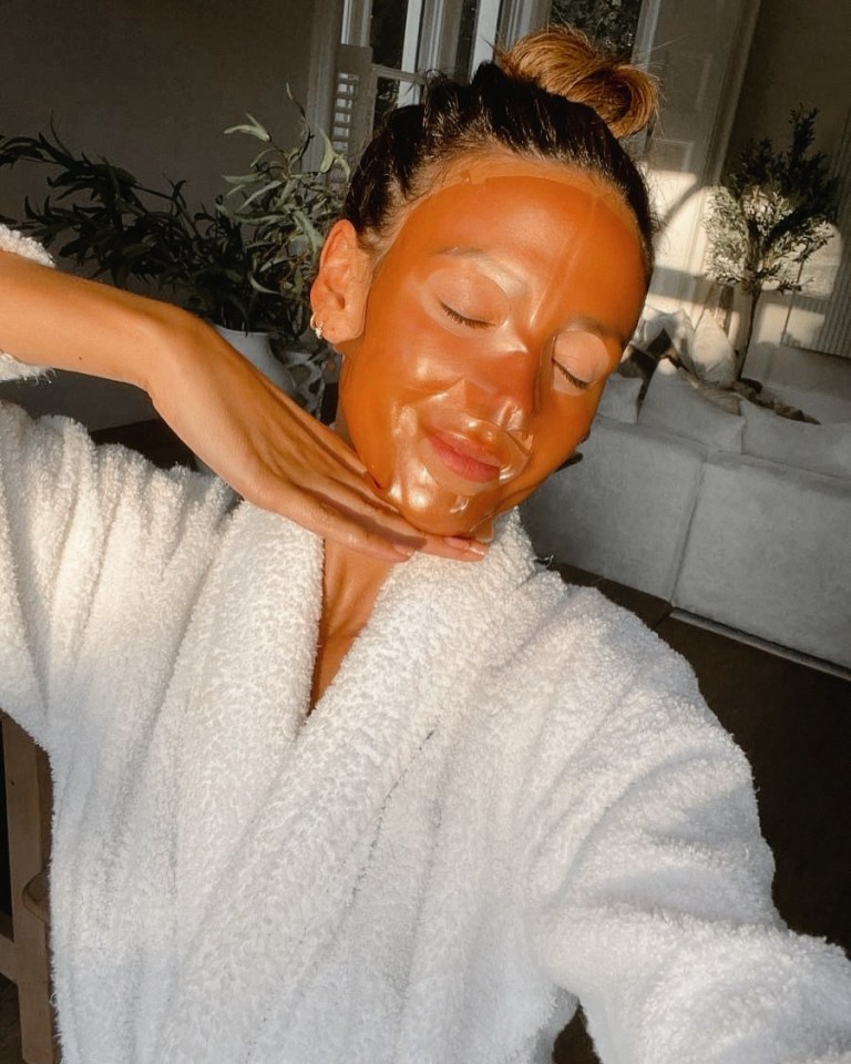 Woman in bathrobe wearing a face mask.